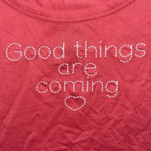 A croped peach shirt that has a little saying “Good things are Coming”.